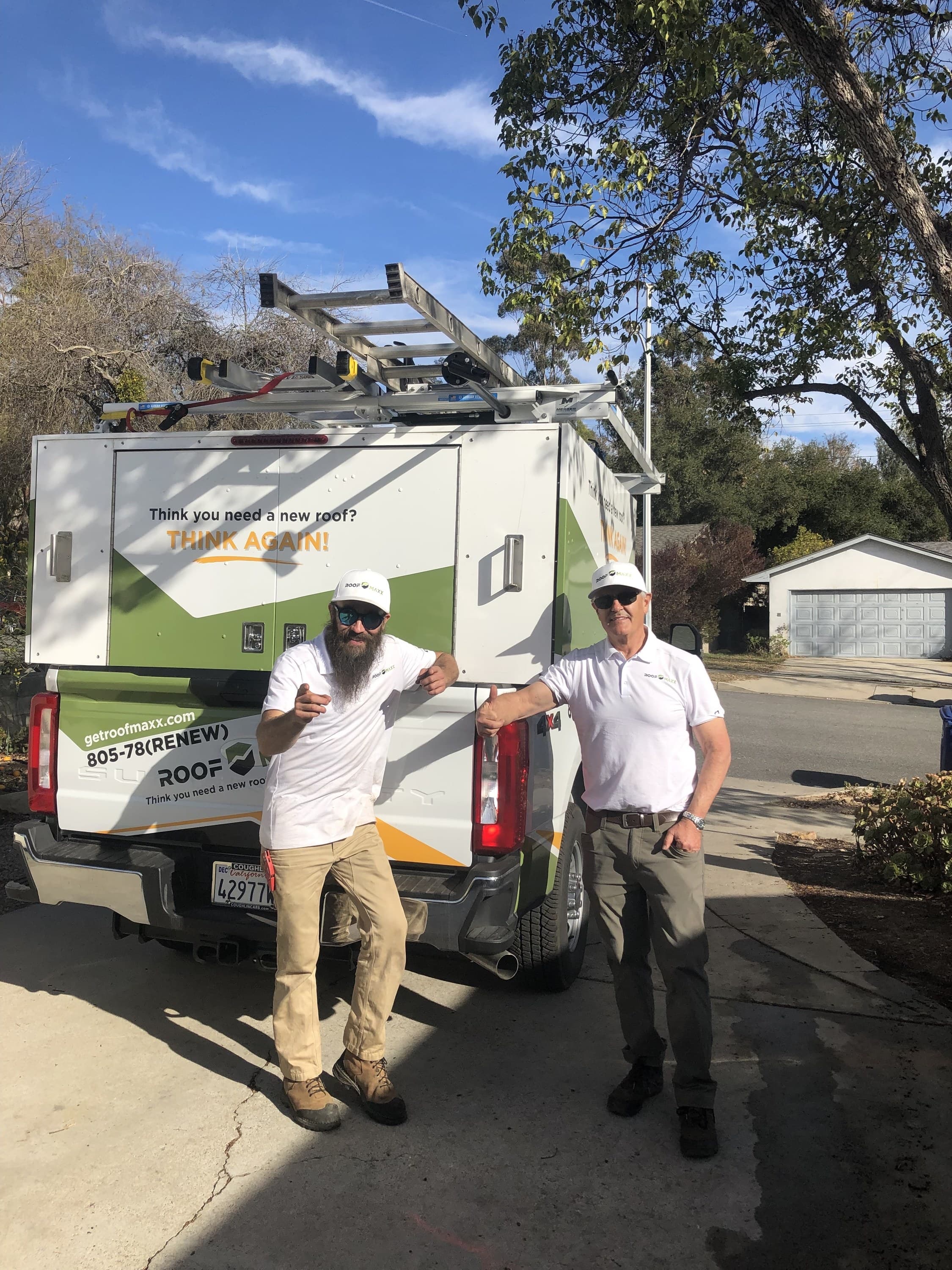 Co-owner Mark Monro and a field lead standing at the back of the work truck