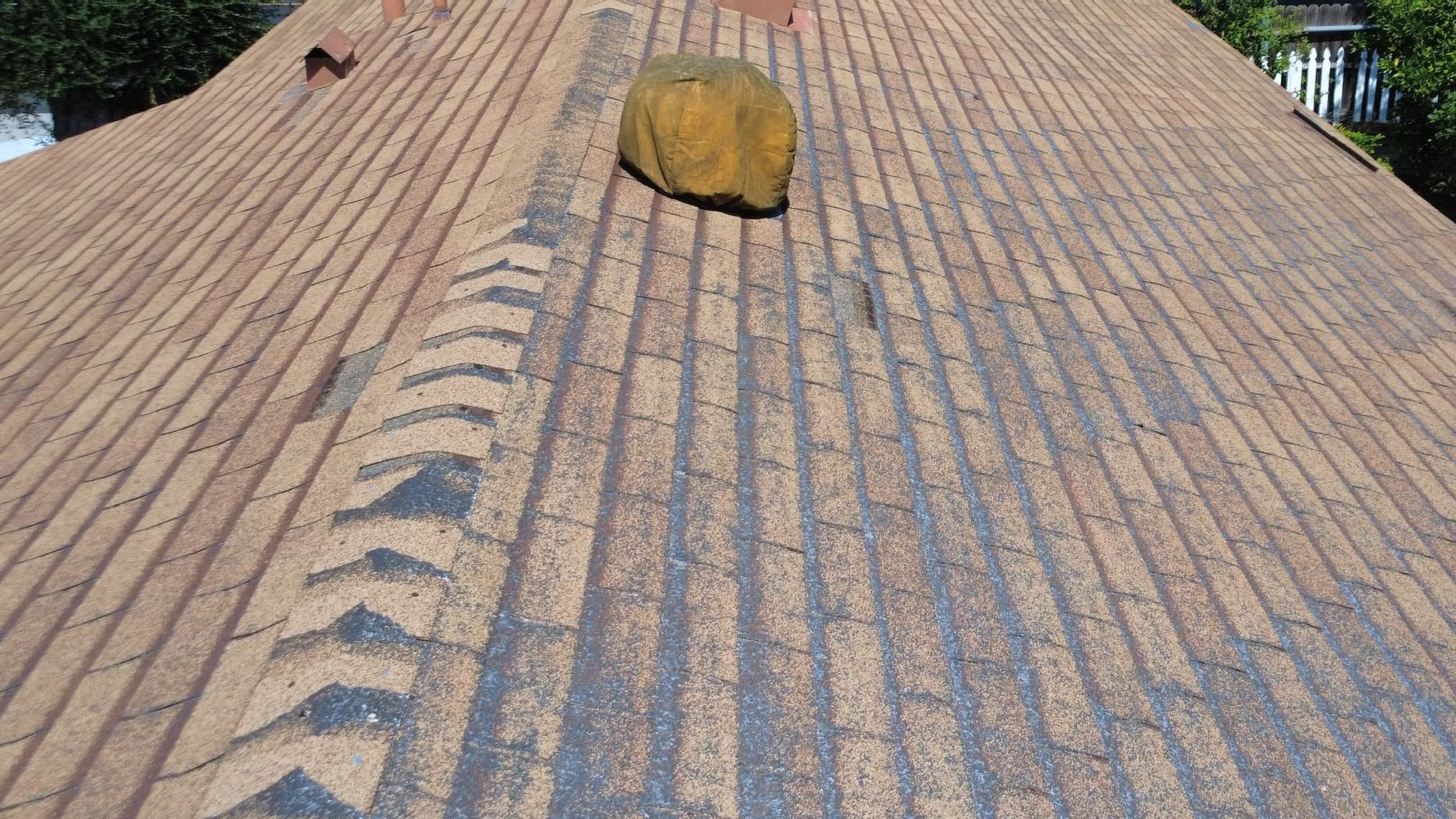 The same Simi Valley roof from directly overhead, pale worn channels running down from the keyways across the whole field on both sides of the ridge.