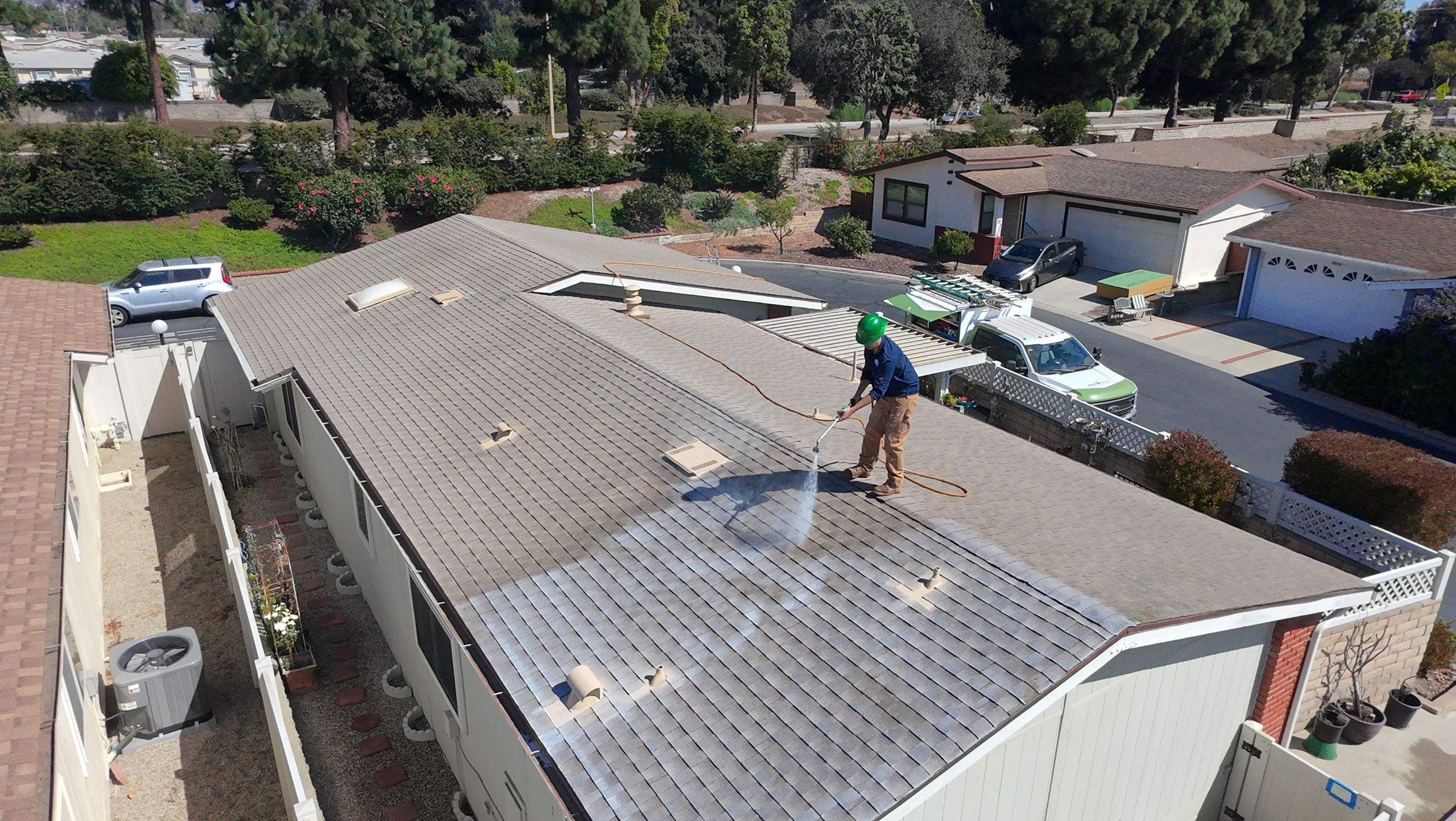 A technician on a ladder working the eave course of a manufactured home in Ventura.