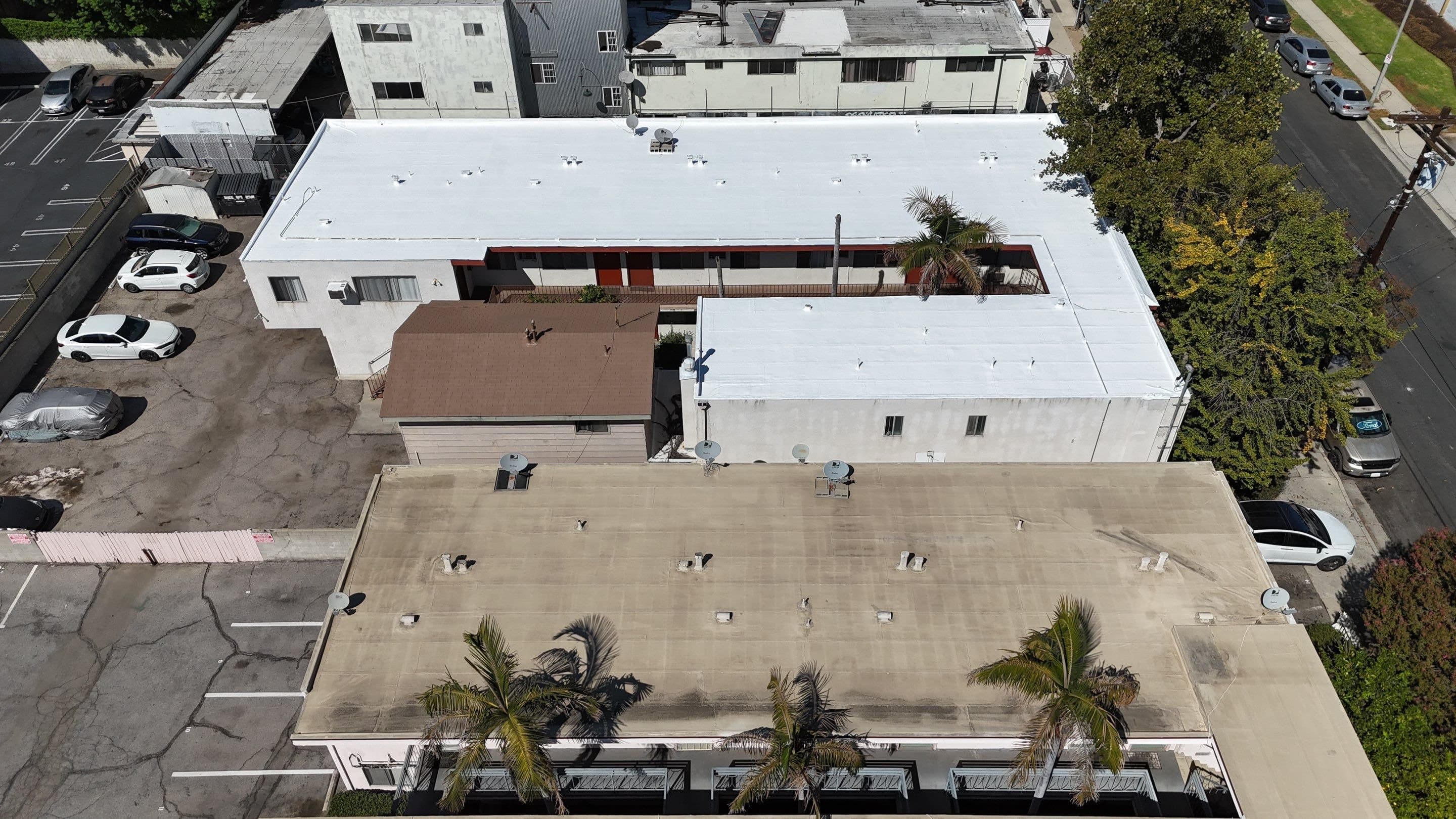 Aerial view of the finished white flat roof and the coated detached building.