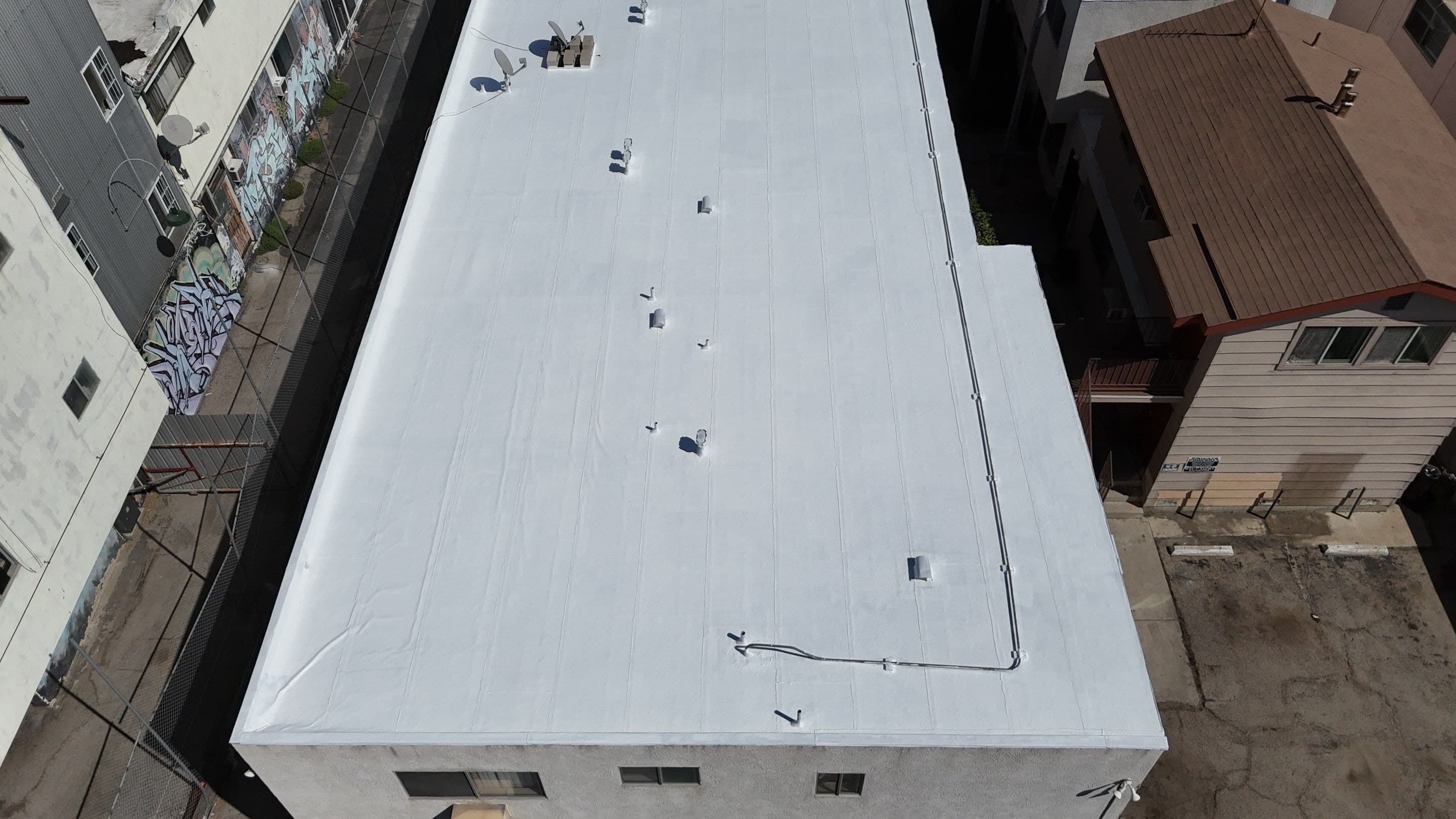 The finished white roof seen from the eave, looking across the field.