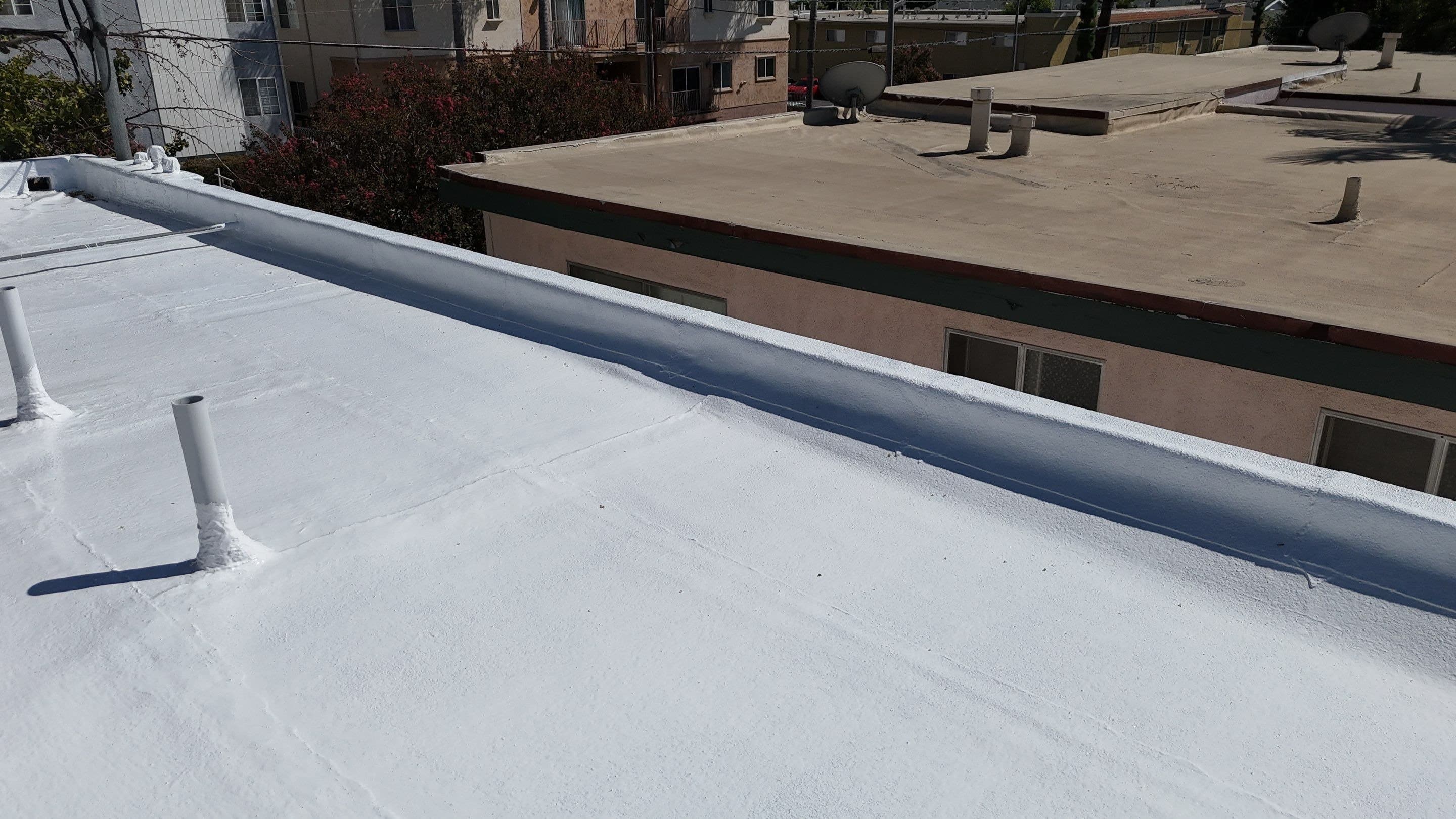 Penetrations sealed and coated in the finished white roof.