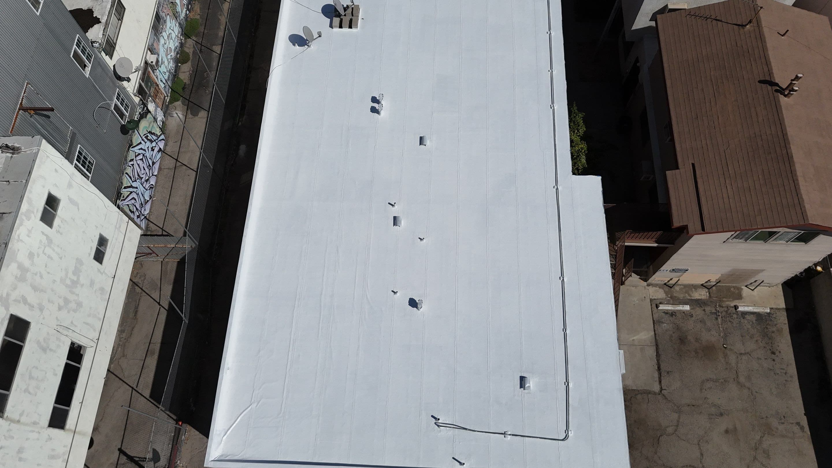 A long aerial view of the finished white roofs.