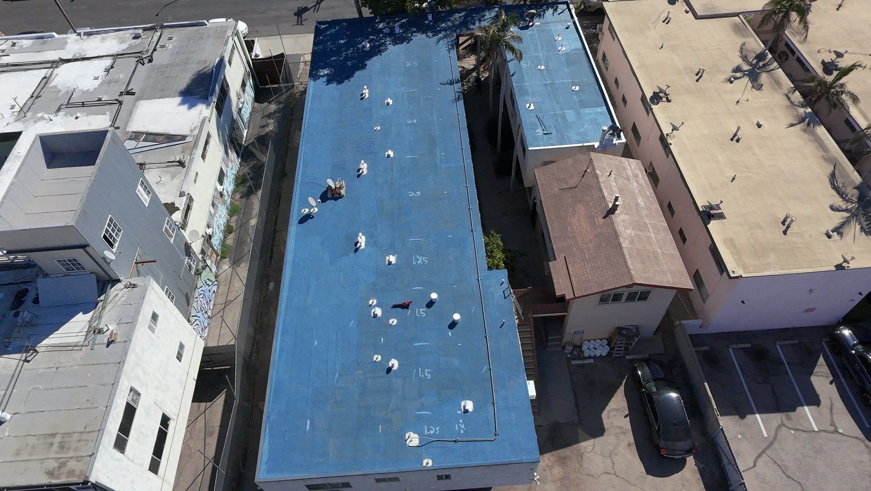 Aerial view of the flat roof covered in blue silicone base coat.