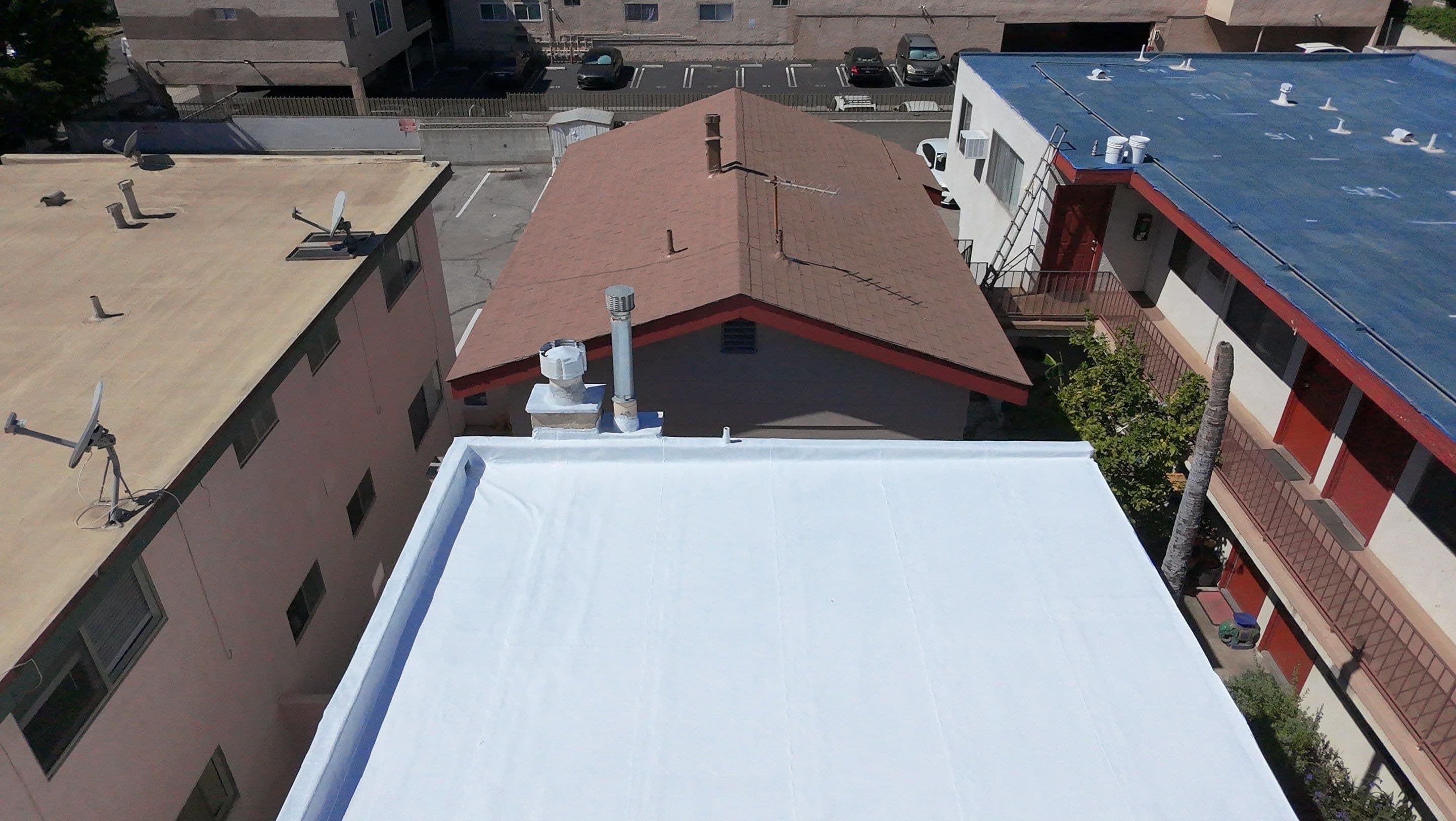 Close view of white coating over repaired shingles, with the courses still visible.