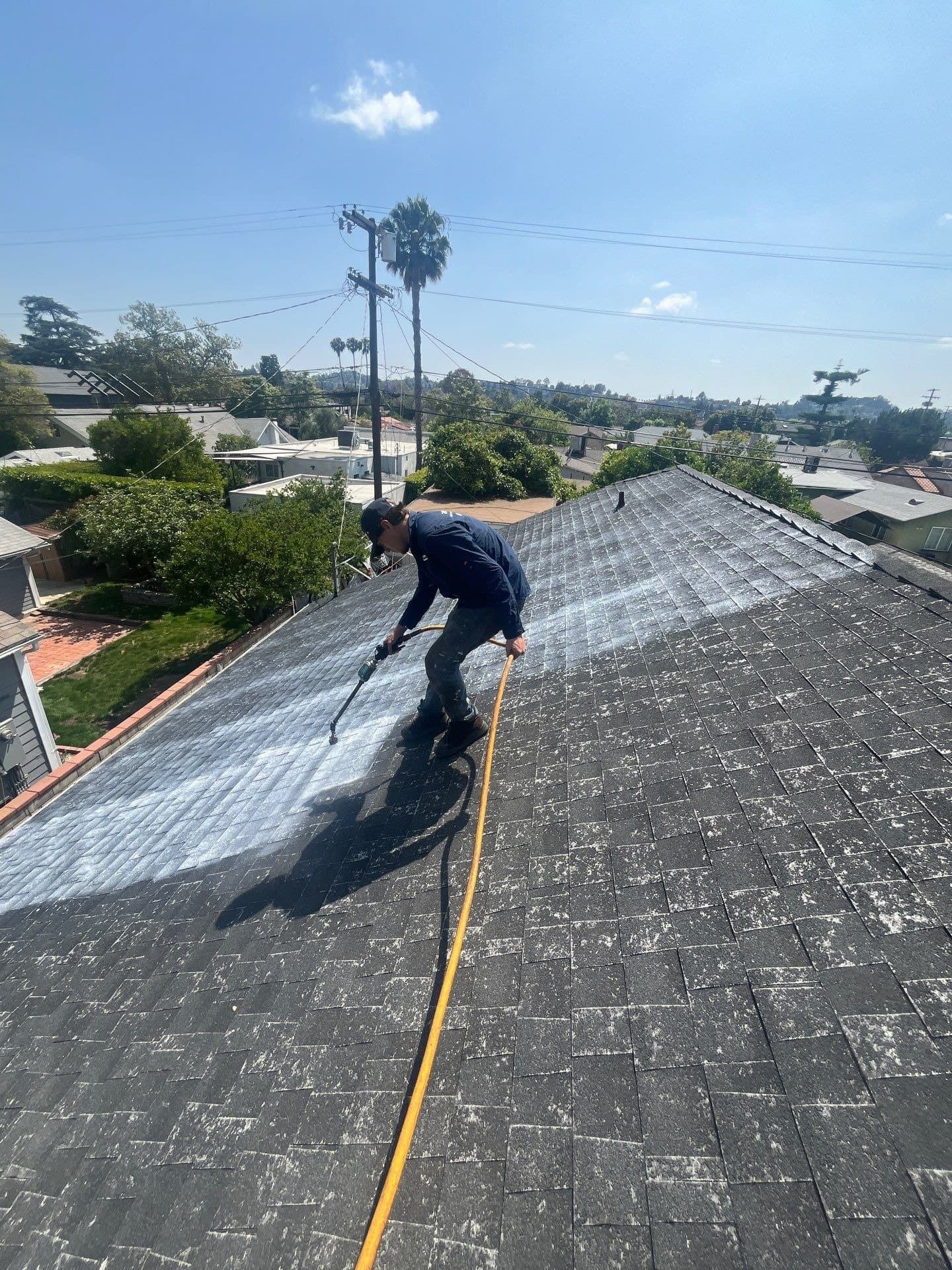 A crew spraying Roof Maxx down the slope of a home in Atwater Village, Los Angeles.