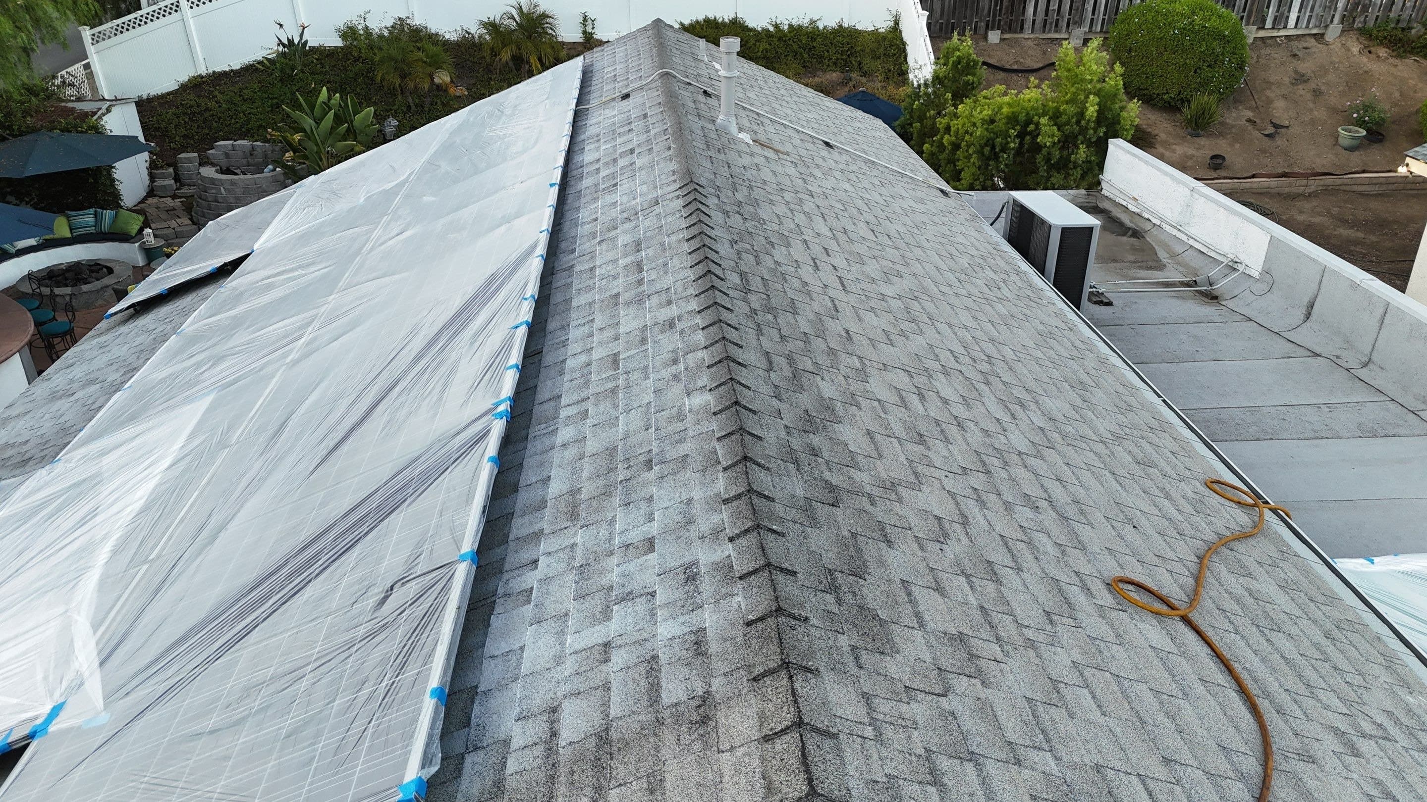 Overhead view of Roof Maxx being sprayed from the ridge toward the eave on a Thousand Oaks roof.