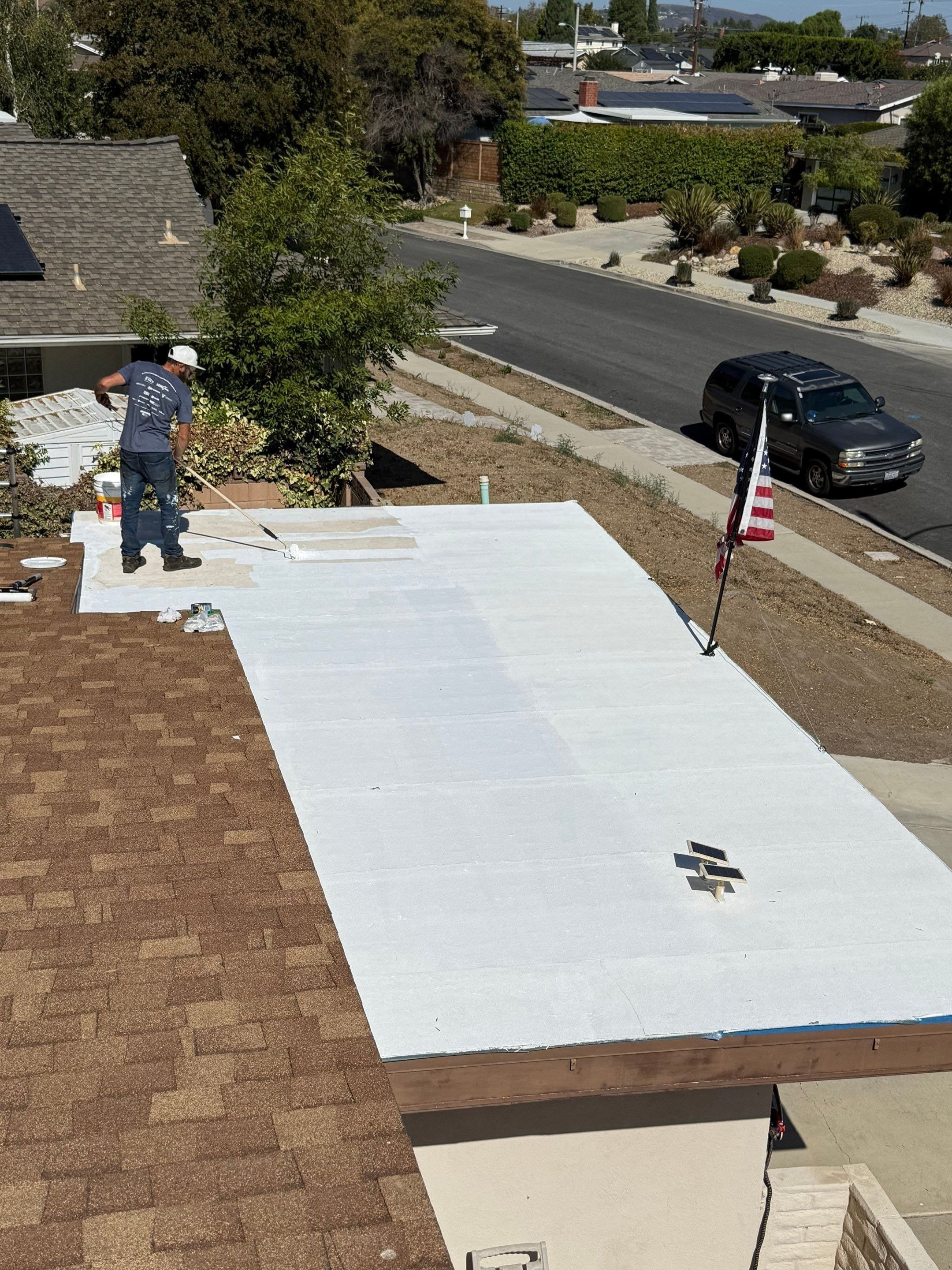 A Thousand Oaks house with a brown shingle roof beside a flat deck coated bright white.